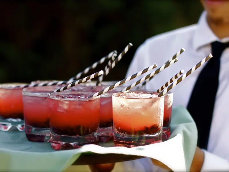 A tray of drinks with straws on top.